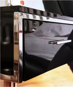 a black microwave oven sitting on top of a wooden table