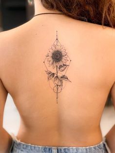 the back of a woman's shoulder with a sunflower tattoo design on it