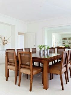 a dining room table surrounded by chairs and vases