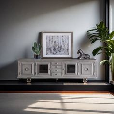 a living room scene with focus on the entertainment center and potted plant next to it