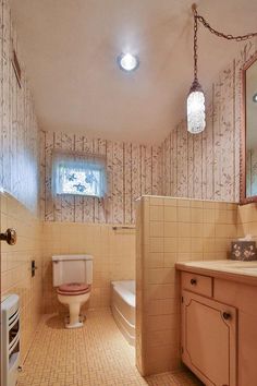 a bathroom with a toilet, sink and bathtub in the corner next to a window