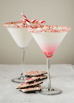 two martini glasses filled with candy canes and sprinkles next to each other