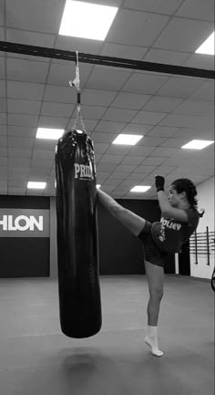 a woman kicking a punching bag in a gym