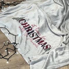 an old t - shirt with the word christmas on it is laying on top of a wooden floor