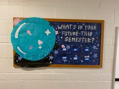 a blue paper plate sitting on top of a wall next to a sign that says what's in your future - this semester