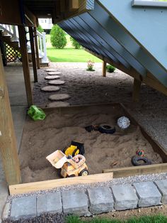 a pile of sand sitting under a wooden structure