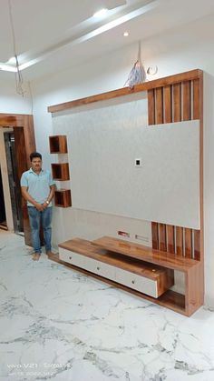 a man standing in front of a tv on top of a wooden entertainment center unit