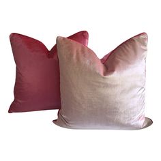 two pink and white pillows sitting next to each other