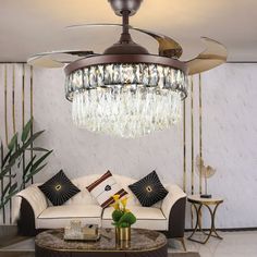 a living room filled with furniture and a chandelier hanging from the middle of it