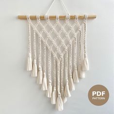 a white wall hanging with tassels on it