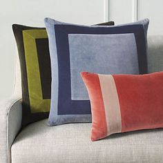 three pillows sitting on top of a couch