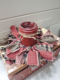 a red mason jar sitting on top of a wooden box