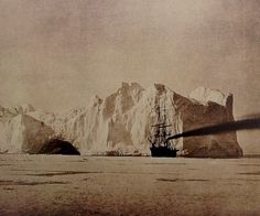 an old photo of a ship in front of icebergs