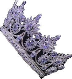 a tiara with purple and silver crystals on the top, sitting in front of a white background