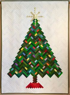 a quilted christmas tree is hanging on the wall