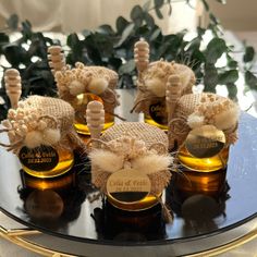 four small bottles filled with honey sitting on top of a table