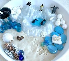 a bowl filled with different types of rocks and sea animals on top of snow covered ground