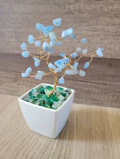 a small white vase with blue sea glass in it