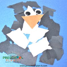 a penguin made out of construction paper on a blue background