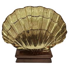 a large golden shell on a wooden base