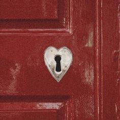 a red door with a heart shaped keyhole