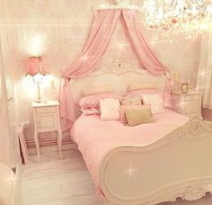 a pink bedroom with white furniture and chandelier