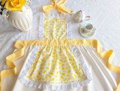 a yellow and white polka dot dress next to flowers