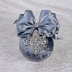 an ornament with a snowflake on it and a bow around the top