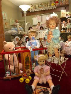 a group of dolls sitting on top of a red rug in a room filled with teddy bears