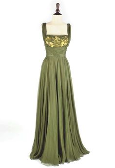 a green dress with gold appliques on it