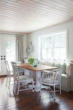 a dining room table and chairs in front of a window