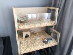 a cat house built into the side of a shelf filled with sand and other items