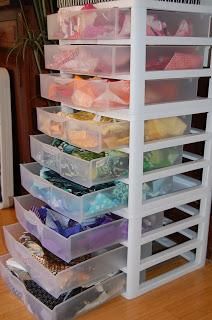 a stacking shelf filled with lots of plastic containers on top of a hard wood floor