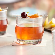 two glasses filled with drinks sitting on top of a table