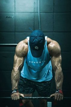 a man in blue shirt and black shorts lifting a barbell