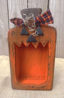 an orange glass bottle with a bow on it's head and some metal decorations