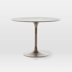 an oval marble table with metal pedestals on the top and base, in white background