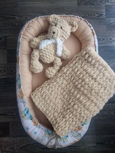 a crocheted teddy bear and blanket on a wooden floor