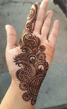 a hand that has a henna on it and is showing the intricate design in the middle