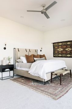 a bedroom with a bed, rug and ceiling fan