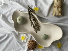 an assortment of decorative items displayed on a white bed with yellow flowers and bamboo sticks