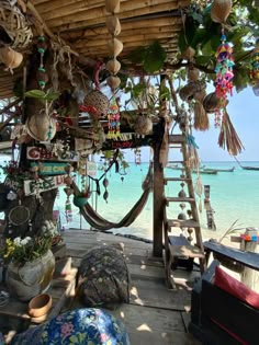 an outdoor area with various items hanging from the roof and in front of the ocean