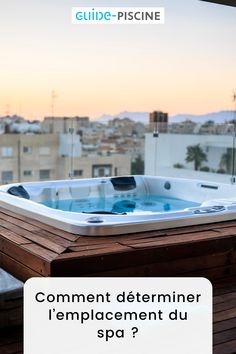 a hot tub sitting on top of a wooden deck next to a cityscape