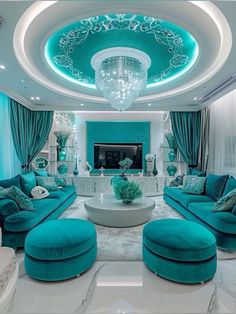 a living room filled with blue couches and white tables under a chandelier