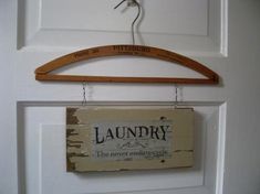 an old laundry sign hanging on a door hanger with clothes pins attached to it