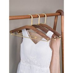 a white dress hanging on a wooden hanger