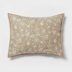 a beige pillow with white flowers on it