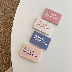 four small thank you cards on top of a white table next to a brown carpet