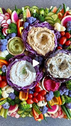 an array of vegetables and dips arranged in the shape of a circle on a platter