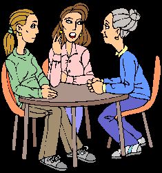 three people sitting at a table talking to each other